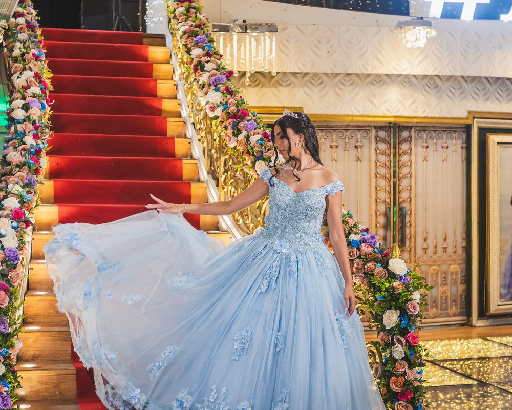 Debutante de vestido azul na escadaria florida do Palace Hall